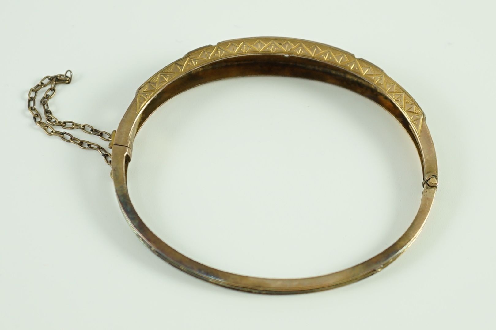 A late Victorian engraved gold, gypsy set three stone diamond and four stone sapphire set hinged bangle